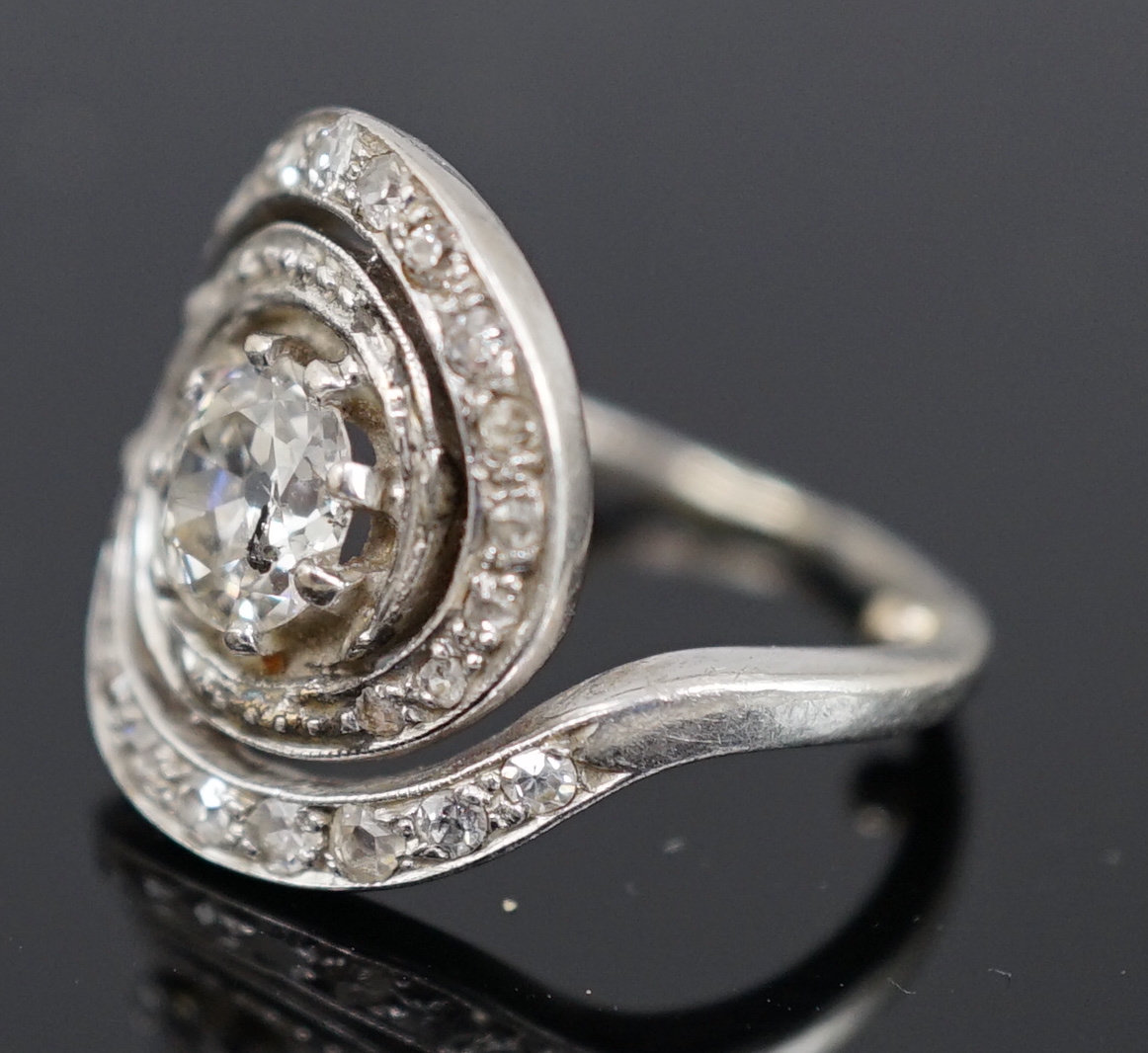 A mid 20th century platinum and diamond cluster set ring, of spiralling design